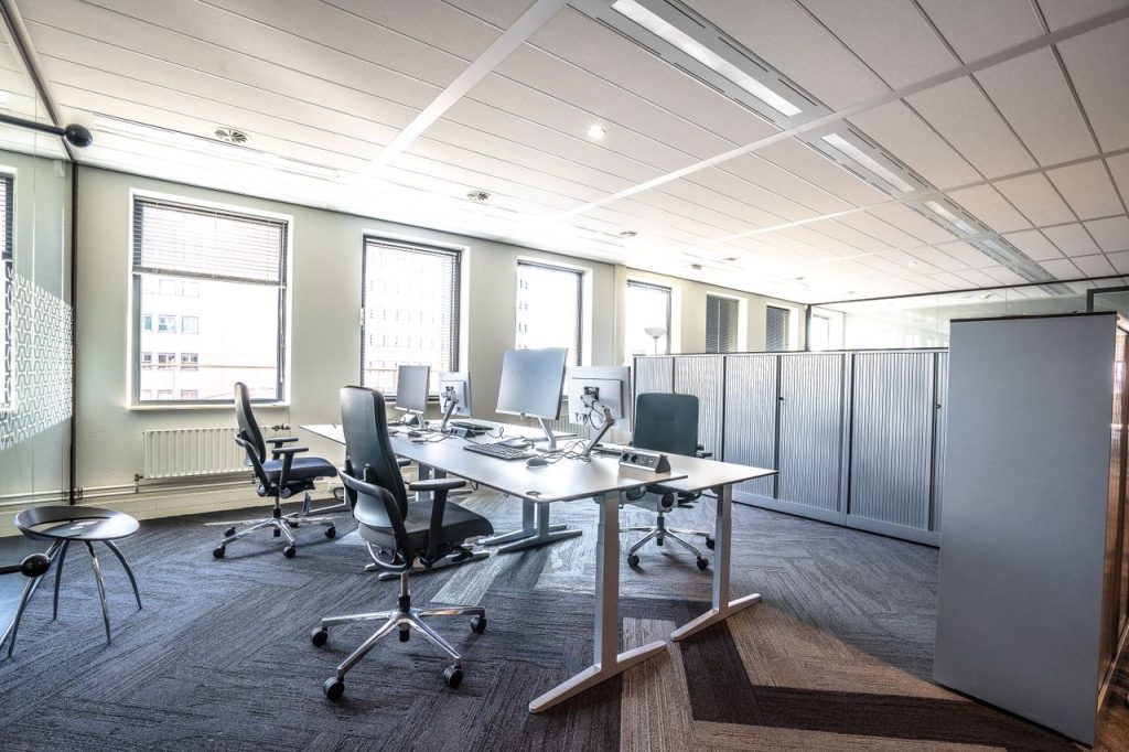 Bright and spacious modern office interior featuring sleek workstations and ergonomic chairs.